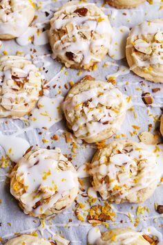 there are many cookies with icing and nuts on the table