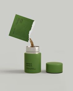 a green canister with a piece of paper sticking out of it