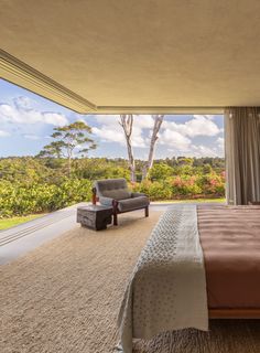 a large bed sitting in a bedroom next to a window with a view of the forest