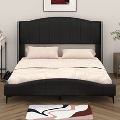 a large bed sitting on top of a hard wood floor next to a white wall