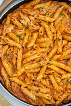 pasta with sauce and parmesan cheese in a skillet on a wooden table