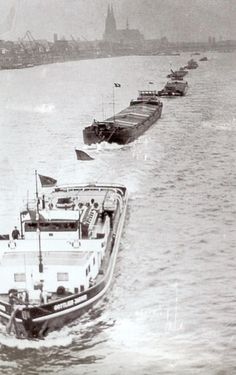 several boats are lined up on the water near each other in this black and white photo