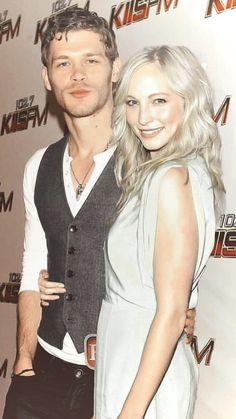 a man and woman standing next to each other on a red carpet at an event