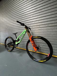 a bike leaning against a garage door in front of a wall with yellow and green stripes