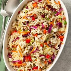 a white bowl filled with coleslaw and carrots on top of a green napkin