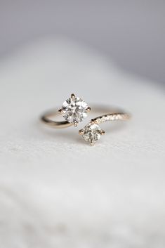 an engagement ring with a single diamond on the top and two smaller diamonds on the bottom