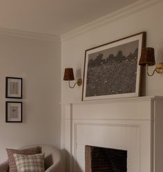 a living room with a fire place and pictures on the wall above it's mantle