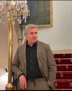 a man standing in front of a chandelier