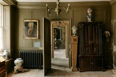 an old fashioned room with antique furniture and paintings on the walls