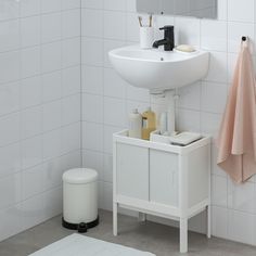 a white sink sitting under a bathroom mirror