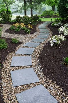 a stone path in the middle of a garden