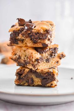 three chocolate chip cookie bars stacked on top of each other in front of the camera