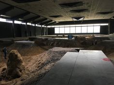 an indoor skate park with ramps and dirt