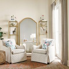 a living room with two chairs and a mirror