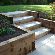 an outdoor garden with steps leading up to the grass