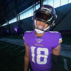 a man wearing a football uniform and helmet standing in front of a building at night