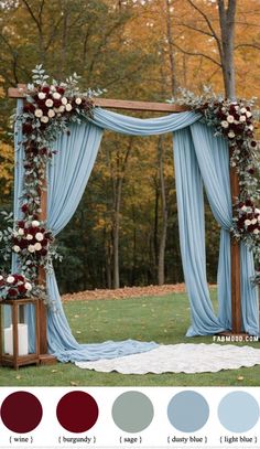 an outdoor wedding ceremony setup with blue drapes, flowers and greenery on it