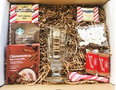 an open box containing coffee, hot cocoa, marshmallows and other snacks