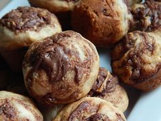 a white plate topped with lots of chocolate covered muffins on top of each other