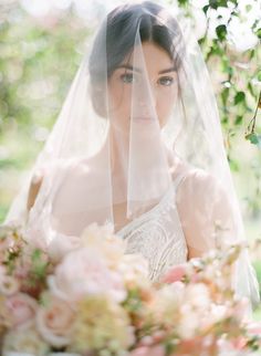 a woman wearing a veil and holding a bouquet