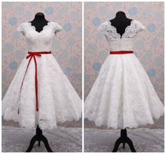 a white dress with red ribbon on the waist