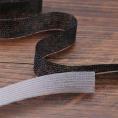 a black and white ribbon laying on top of a wooden floor