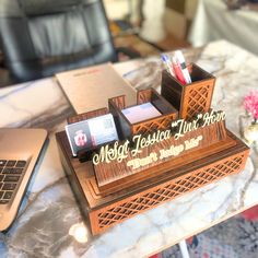 a desk with a laptop, pen holder and other items on top of the table