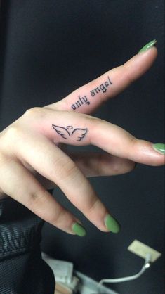 a woman's hand with two finger tattoos on it