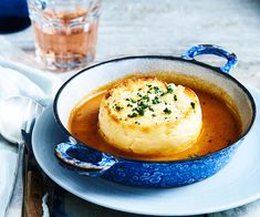 a bowl filled with soup on top of a white plate