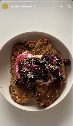 a white bowl filled with french toast topped with berries