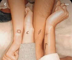 two people with matching tattoos on their arms and feet, one holding the other's hand