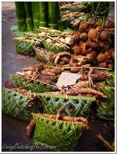 several baskets filled with food sitting on top of a table next to green bamboo poles