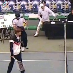 a young man holding a tennis racquet on top of a tennis ball court