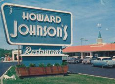 the sign for howard's restaurant is in front of an old car dealership