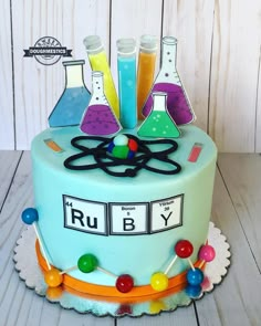 a cake decorated with colorful flasks and test tubes on it's side