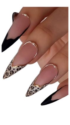 a woman's nails with leopard print and black stilts on them, both in gold