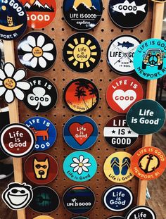 there are many different badges on the wall in this shop, including life is good and life is good