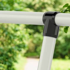 a close up of a white and black pole with green trees in the back ground