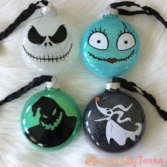 three ornaments with faces painted on them