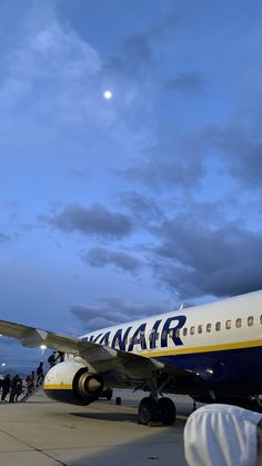 an airplane is parked on the tarmac with people standing around it and looking at it