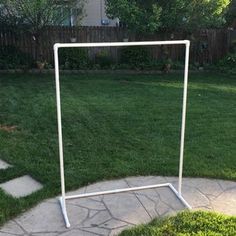 a white soccer goal in the middle of a yard