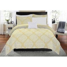 a yellow and white comforter set with pillows