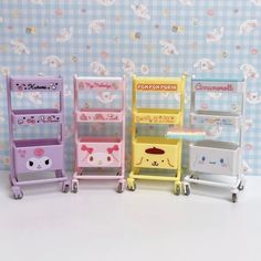 four different colored toy carts with hello kitty characters on them