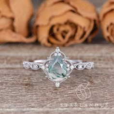 an engagement ring with a pear shaped aqua blue topazte surrounded by white diamonds