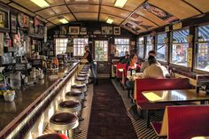 people sitting at tables in a restaurant with lots of pictures on the walls and ceiling