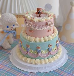 there is a three layer cake with teddy bears on the top and bottom tiers