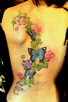 a woman with a butterfly and flowers tattoo on her back