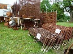 many baskets are stacked up on the grass in front of a building with several forks sticking out of them