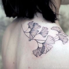 the back of a woman's shoulder with flowers tattoo on her upper arm and chest