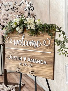 a wooden welcome sign with flowers on it